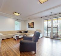 5-izbový dom 170m² + pozemok 529m² | Podunajské Biskupice - Obývačka v rodinnom dome s krbom, sedačkou a podlahou s dreveným dekorom.