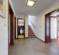 5-izbový dom 170m² + pozemok 529m² | Podunajské Biskupice - Vstupná hala v rodinnom dome s múrmi, dverami a schodiskom. Podlaha s dreveným dekorom.