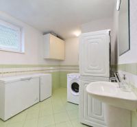 5-izbový dom 170m² + pozemok 529m² | Podunajské Biskupice - Priestranná práčovňa v rodinnom dome so svetlozelenou dlažbou a práčkou.