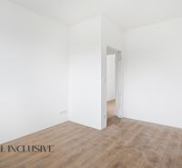 Na predaj 4-izbové novostavby, Veľká Paka - Biela izba s podlahou s dreveným dekorom v rodinnom dome.
