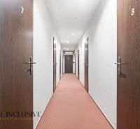 Na prenájom podnikateľské priestory, Senec - Hotelová chodba s číslovanými dverami a červeným kobercom.