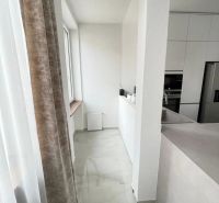Veľkorysý 3 izbový byt 87m2 po rekonštrukcii, Wiener Neustadt - Kuchyňa v 3-izbovom byte s bielymi skrinkami a mramorovou podlahou.