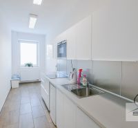 Bez provízie RK | Kancelárie | 24 m² – 46 m² | parkovanie | Svornosti - Kuchynské zariadenie v kancelárii so svetlým nábytkom a spotrebičmi, s podlahou s dreveným dekorom.