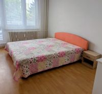 2izbový byt na prenájom v Dubnici nad Váhom  - Spálňa s posteľou a patchworkovým prehozom v 2-izbovom byte, podlaha s dreveným dekorom.