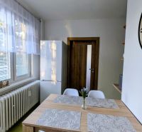 2izbový byt na prenájom v Dubnici nad Váhom  - Jedálenský kút v 2-izbovom byte s dreveným stolom a bielymi stoličkami.