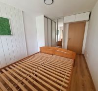 NA PRENÁJOM 2 IZBOVÝ TEHLOVÝ BYT, 55 M2, PREŠOV, ŠIRŠIE CENTRUM - Spálňa v 2-izbovom byte s drevenou posteľou, vstavanou skriňou a dekoráciou na stene.
