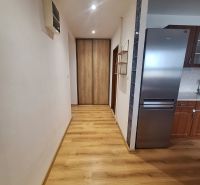 NA PRENÁJOM 2 IZBOVÝ TEHLOVÝ BYT, 55 M2, PREŠOV, ŠIRŠIE CENTRUM - Chodba so vstavanou skriňou a kuchyňou v 2-izbovom byte, drevená podlaha, svetlé steny.