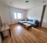 NA PRENÁJOM 2 IZBOVÝ TEHLOVÝ BYT, 55 M2, PREŠOV, ŠIRŠIE CENTRUM - Obývačka v 2-izbovom byte s pohovkou, stolíkmi a drevenou podlahou.
