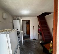 Vidiecky dom na predaj Mikulášov - Interiér rodinného domu s chladničkou, bojlerom a drevenými schodmi.