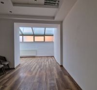 PRENÁJOM Priestory Poprad - Námestie Sv.Egídia - prízemie - 35 m2 - Interiér obchodných priestorov s podlahou s dreveným dekorom a radom stoličiek.