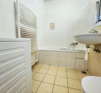 - PRENÁJOM - 2 IZBOVÝ BYT - JAKUBOVO NÁMESTIE - STARÉ MESTO - Kúpeľňa v 2-izbovom byte s vaňou, umývadlom a práčkou, obložená bielymi obkladačkami.