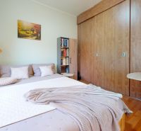 Predaj rodinného domu v Sládkovičove - Spálňa v rodinnom dome s veľkou posteľou, lampou a skriňou s dreveným dekorom.