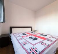 | priestranný | 2i byt s balkónom | parkovaním | Koprivnická - Spálňa v 2-izbovom byte s posteľou a podlahou s dreveným dekorom.