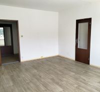 3-izbový byt s možnosťou zmeny na 4-izbový, Martin - Záturčie - Priestranná izba v 3-izbovom byte s podlahou s dreveným dekorom a bielymi stenami.