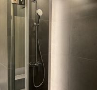 I Predaj Výnimočný  1-izb apartmán v projekte Metropolis - Sprchový kút so sivými obkladmi v 1-izbovom byte.