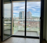 I Predaj Výnimočný  1-izb apartmán v projekte Metropolis - Výhľad na centrum Bratislavy z 1-izbového bytu s balkónom a podlahou s dreveným dekorom.
