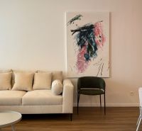 NA PRENÁJOM 2 izbový byt priamo v centre Nitry  - Obývacia izba v 2-izbovom byte s béžovou sedačkou, abstraktným obrazom a podlahou s dreveným dekorom.