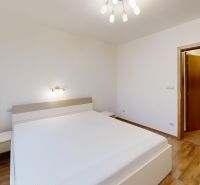 Priestranný a zariadený 3-izbový byt s lodžiou, Drobného - Svetlá spálňa s posteľou, podlahou s dreveným dekorom a minimalistickým osvetlením v 3-izbovom byte.