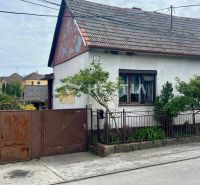 NOVINKA NA TRHU | Rodinný dom v obci Cerová – ideálne miesto pre pokoj - Rodinný dom v Cerovej s bránou a malou záhradou, obkolesený zeleňou.