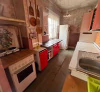 NOVINKA NA TRHU | Rodinný dom v obci Cerová – ideálne miesto pre pokoj - Kuchyňa v rodinnom dome s podlahou s dreveným dekorom a retro nábytkom.