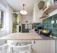 2-izbový byt po rekonštrukcii | Vietnamská ulica, Ružinov | Loggia | B - Kuchyňa v 2-izbovom byte s kuchynskou linkou, dreveným dekorom a zelenými obkladačkami.