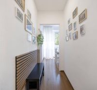 2-izbový byt po rekonštrukcii | Vietnamská ulica, Ružinov | Loggia | B - Chodba v 2-izbovom byte s dekorom podlahy a zavesenými obrázkami na stenách.