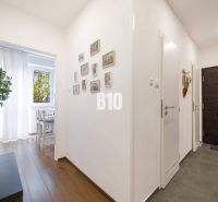 2-izbový byt po rekonštrukcii | Vietnamská ulica, Ružinov | Loggia | B - Chodba v 2-izbovom byte s podlahou s dreveným dekorom a bielymi stenami.