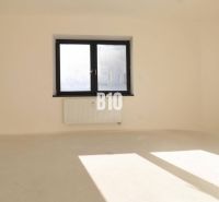 VÝNIMOČNÁ INVESTIČNÁ PRÍLEŽITOSŤ! ADMINISTRATÍVNY PRIESTOR (127,87 m²) - Prázdna kancelária s dvoma oknami a radiátorom, svetlé steny, podlaha bez dekoru dreva.