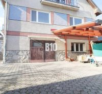 Veľký rodinný dom Turany - Rodinný dom v Turanoch s dreveným prístreškom a príjazdovou cestou.