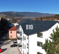 Na predaj byty rôznych veľkostí v bytovom dome REZINDENCIA KUBÍN - Novostavba bytovky v Dolnom Kubíne, s výhľadom na hory a parkoviskom.