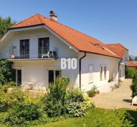 Žabokreky - unikátna nehnuteľnosť pre viacgeneračné bývanie alebo podn - Rodinný dom v Žabokrekoch s červenou strechou, balkónom a okolitou zeleňou.