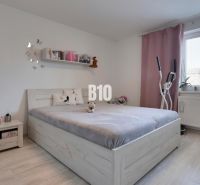 Ideálne bývanie: Zariadený dom 85m² s nízkymi nákladmi - Spálňa s posteľou, podlahou s dreveným dekorom a cvičebným zariadením v rodinnom dome.