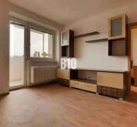 Predaj 1-izbového bytu po čiastočnej rekonštrukcii, Martin – Podháj - Izba s nábytkom, podlaha s dreveným dekorom, balkónové dvere.