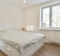 KRÁĽOVSKÝCH 82 m²: Kompletne zrekonštruovaný 3-izbový byt v centre Mar - Spálňa v 3-izbovom byte s posteľou, písacím stolom a podlahou s dreveným dekorom.