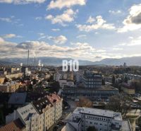 Sad na Studničkách - 2 izbový byt 60m2 - Mesto Žilina s panorámou, bytové domy a priemyselná zóna v popredí.