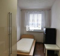 Priestranný 4 izbový byt - Solinky - Jednoducho zariadená izba s jedným lôžkom a podlahou s dreveným dekorom v 4-izbovom byte.