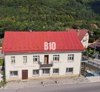 Teraz zľava 30.000 TOP INVESTIČNÁ PRÍLEŽITOSŤ Polyfunkčný objekt na pr - Budova v Belej s červenou strechou, obklopená zeleňou a cestou v popredí.