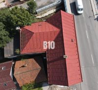 Teraz zľava 30.000 TOP INVESTIČNÁ PRÍLEŽITOSŤ Polyfunkčný objekt na pr - Strecha budovy v Belej a cesta s autami z vtáčej perspektívy.