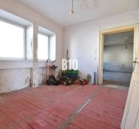 Rodinný dom na rekonštrukciu, 660m2 pozemok. - Izba v rodinnom dome s červenou podlahou a oknami, Bytča.