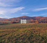 Slnečný pozemok s krásnym výhľadom, 1375m2. - Na obrázku je jesenná krajina s lúkou a kopcami vhodná na pozemky a bývanie.