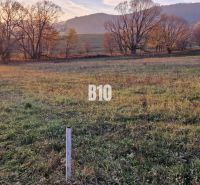 Slnečný pozemok s krásnym výhľadom, 1375m2. - Západ slnka nad zelenými poľami obklopenými stromami a vrchmi, ideálne pre pozemky - bývanie.
