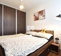 3-izbový byt s parkovaním vo dvore - Spálňa v 3-izbovom byte so vstavanou skriňou a posteľou s dreveným dekorom.