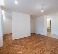 NA PREDAJ štýlový byt v centre Nitry  - Interiér s podlahou s dreveným dekorom a prázdnymi stenami v 3-izbovom byte.