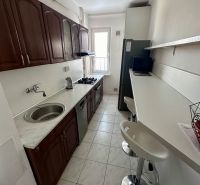 Prenájom moderný 2,5 izbový byt, Šalviová ulica, Bratislava II.Ružinov - Úzka kuchyňa s bielym pultom a drevenými skrinkami v 3-izbovom byte.