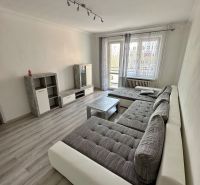 Prenájom moderný 2,5 izbový byt, Šalviová ulica, Bratislava II.Ružinov - Obývačka v 3-izbovom byte s podlahou s dreveným dekorom, veľkou sedačkou a televíziou.