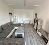 Prenájom moderný 2,5 izbový byt, Šalviová ulica, Bratislava II.Ružinov - Obývacia izba s podlahou s dreveným dekorom a šedou sedacou súpravou v 3-izbovom byte.