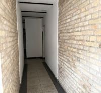VEĽKORYSÝ 2i byt s rozlohou 76 m² v atraktívnej lokalite- Staré mesto - Úzky interiérový priechod s tehlovou stenou a svetlou podlahou v 2-izbovom byte.