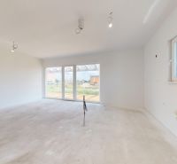 NOVY SVET - SKOLAUDOVANÝ rodinný dom s terasou a parkovaním - Interiér rodinného domu s bielymi stenami a veľkými oknami na záhradu.