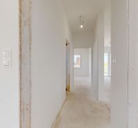 NOVY SVET - SKOLAUDOVANÝ rodinný dom s terasou a parkovaním - Interiér rodinného domu s bielymi stenami a dostupným denným svetlom.