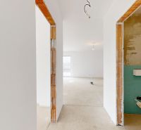 DUNAJSKÁ STREDA- 4i moderná novostavba RD s tep. čerpadlom + garážou - Vo výstavbe rodinného domu je svetlá miestnosť s omietnutými stenami a betónovou podlahou.